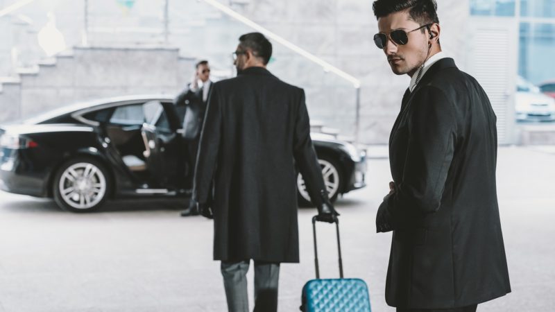 bodyguards going with businessman and reviewing territory near car